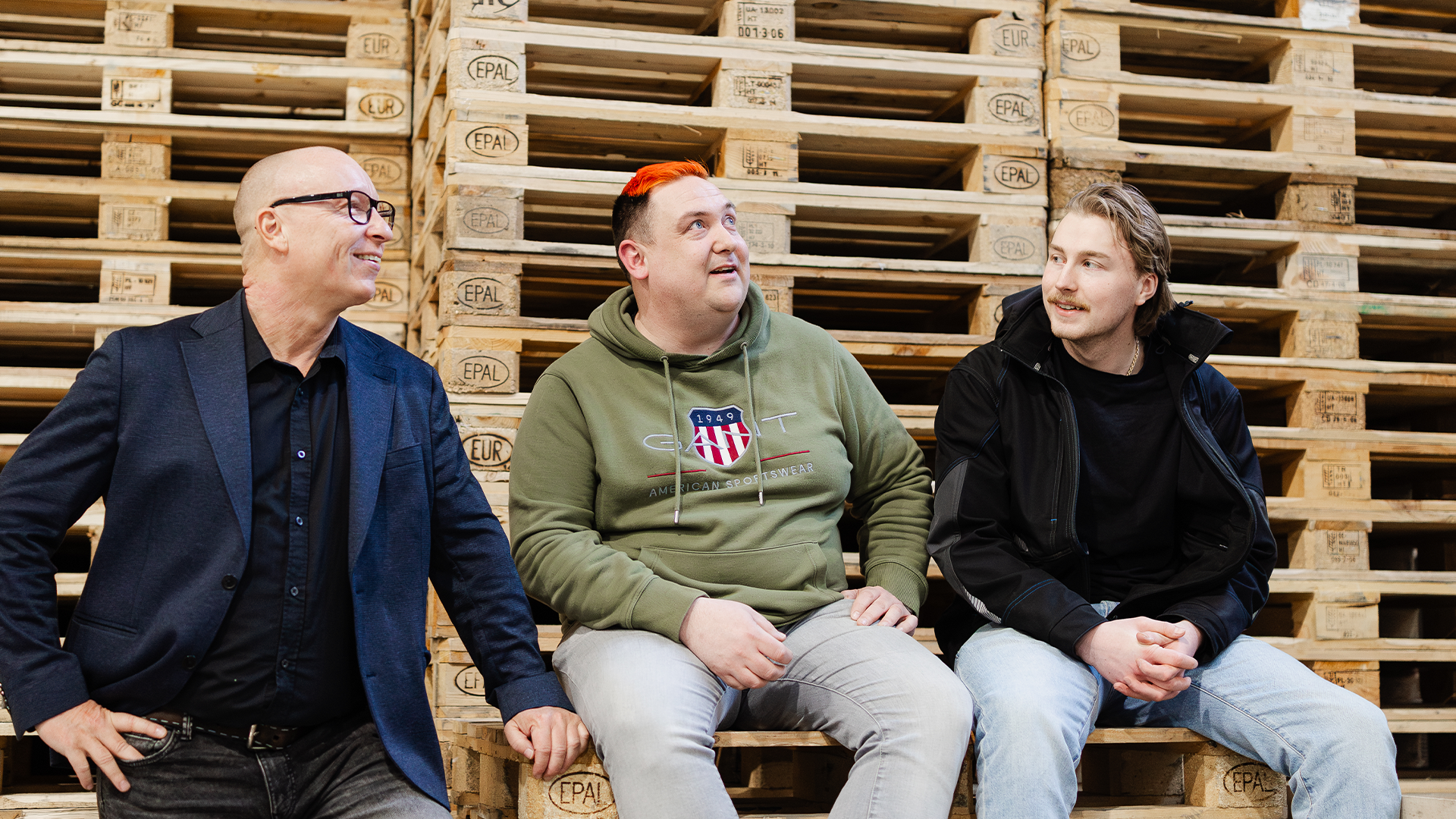 Karri Mutkala, Teemu Forsström ja Valtteri Koskinen istuvat lastauslaiturilla.
