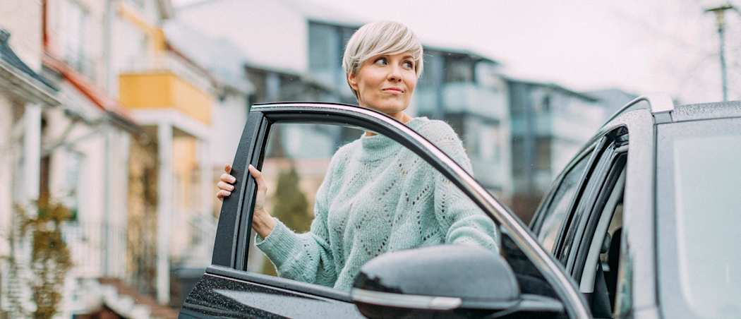 Nainen nousee autosta.