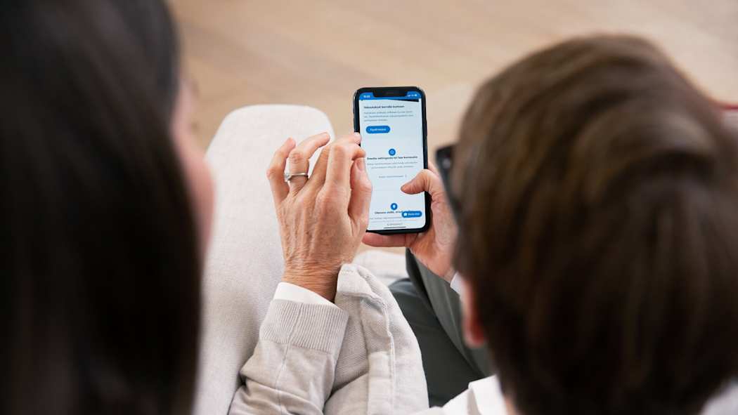 Kaksi naista asioi LähiTapiolan verkkosivulla puhelimella.