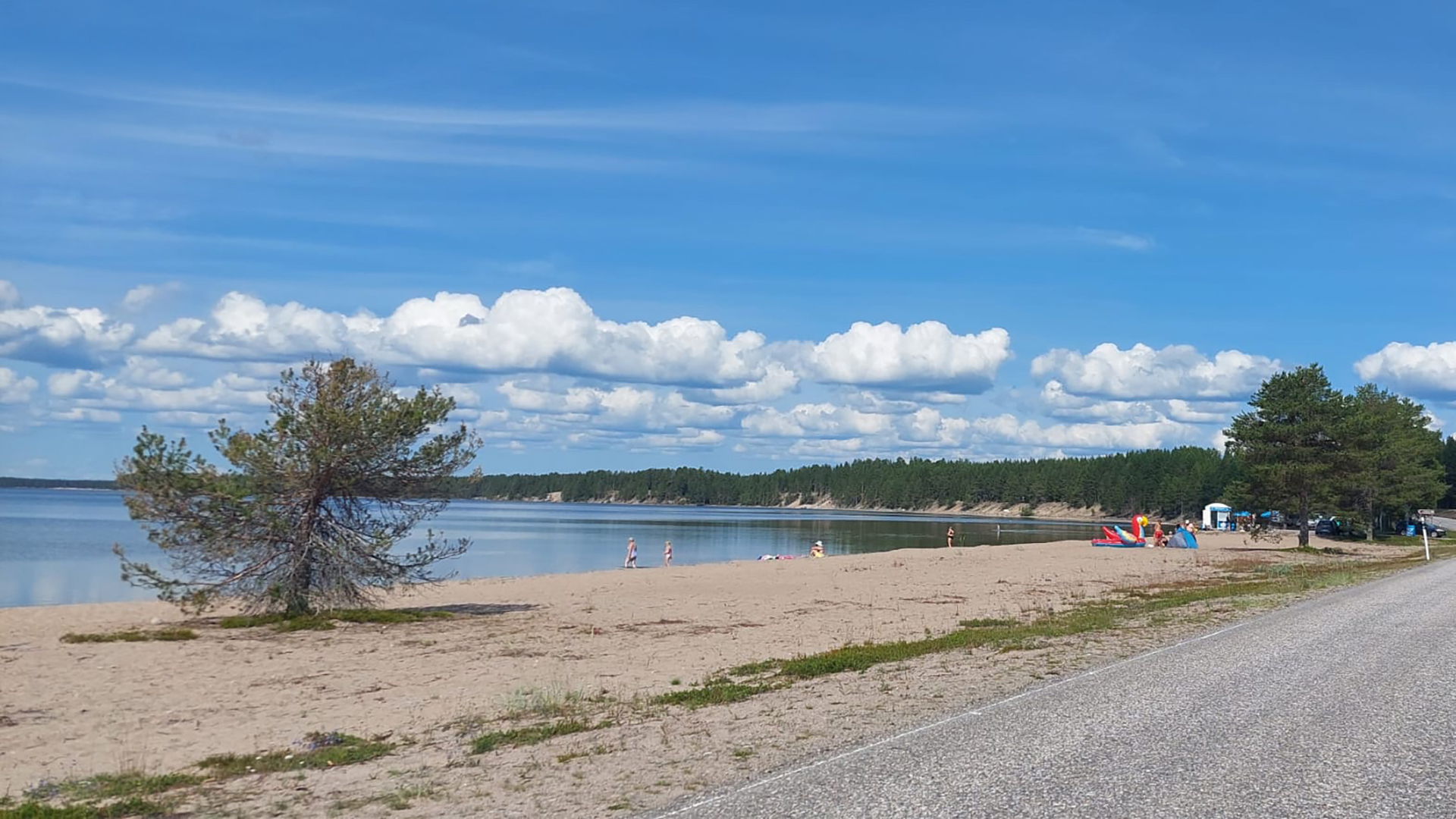 Ihmiset viettävät kesäpäivää Livojärven rannalla uiden ja retkeillen.