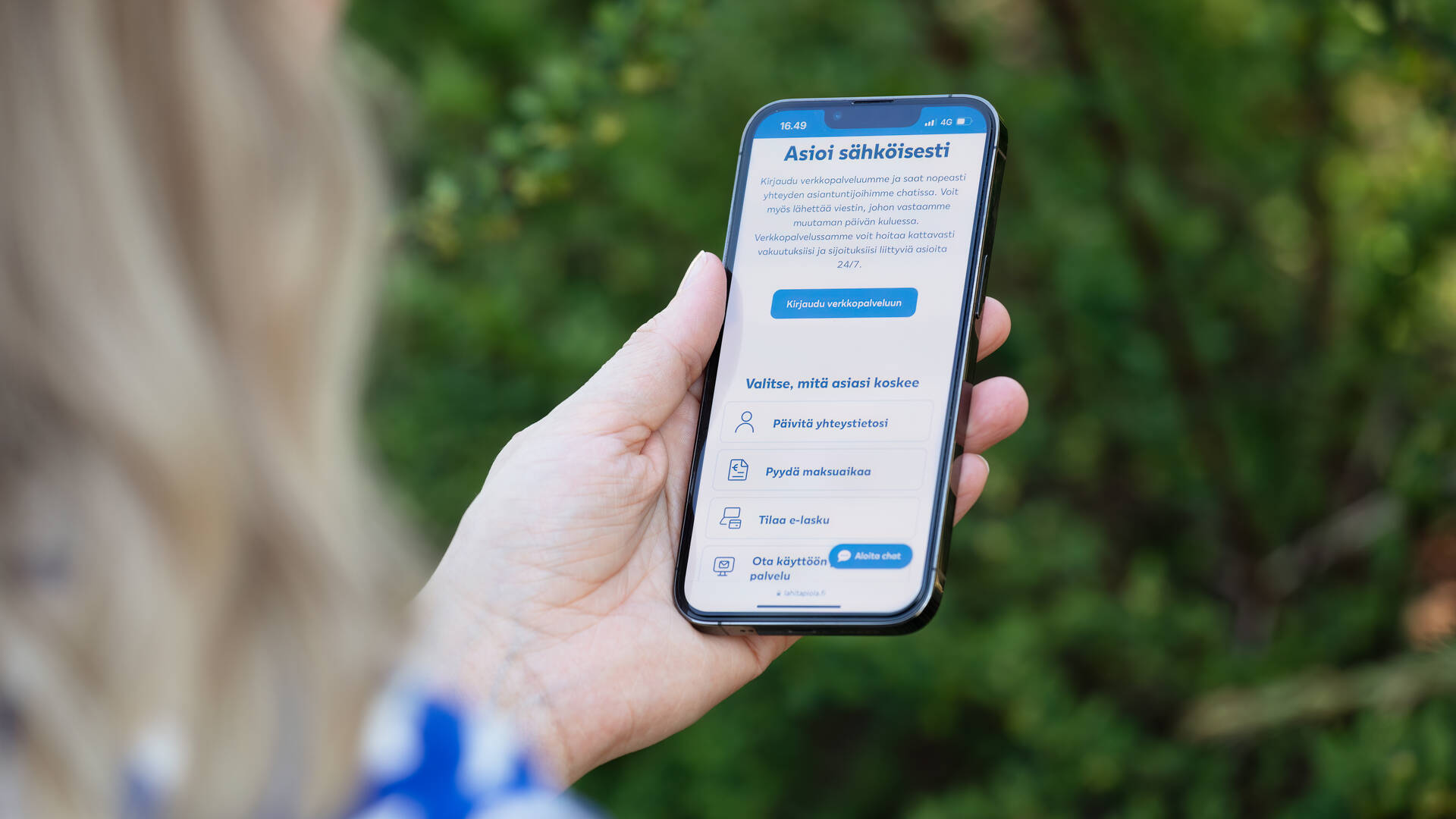 Nainen käyttää LähiTapiolan sähköistä palvelua puhelimellaan.