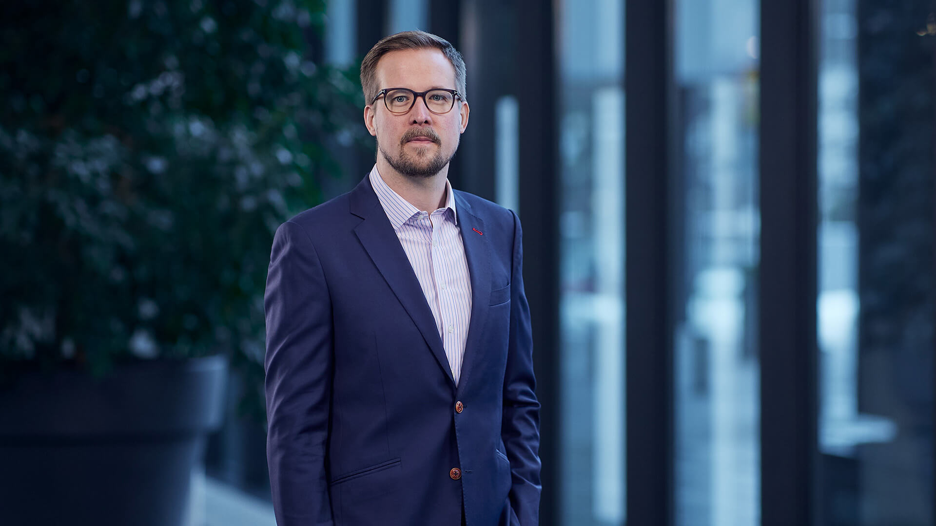 LähiTapiolan Henkivakuutusyhtiön markkinointipäällikkö Tuomo Mikolanniemi kuvattuna LähiTapiolan aulassa puku päällä. Blogissa Mikolanniemi käsittelee sitä, jääkö yrittäjänaiselle lyhyin tikku eläkkeissä.