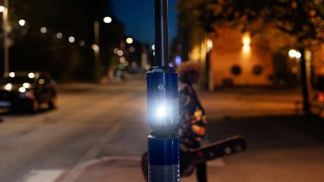 Välkky-suojatievaroitin välkyttää valoa, kun kitaraa kantava mies ylittää suojatietä.