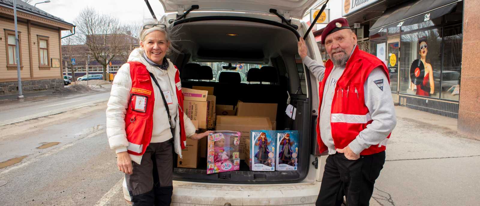 SPR:n Anne-Mari Hakuni pakkaamassa kollegansa kanssa LähiTapiola Länsi-Suomen lahjoittamia leluja pakettiautoon.