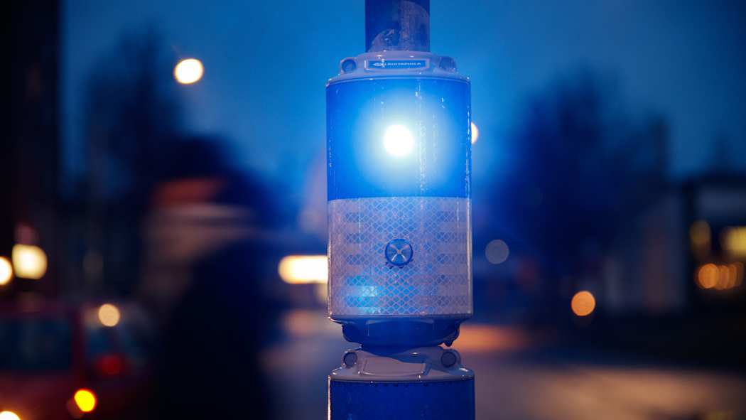 Välkky-suojatievaroitin vilkuttaa valoaan pimenevässä illassa.