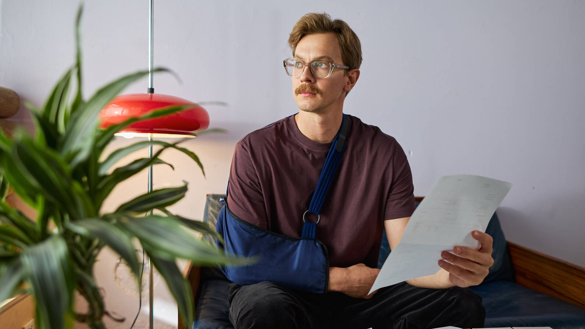 Mies tutkii laskuja keittiönpöydän ääressä.